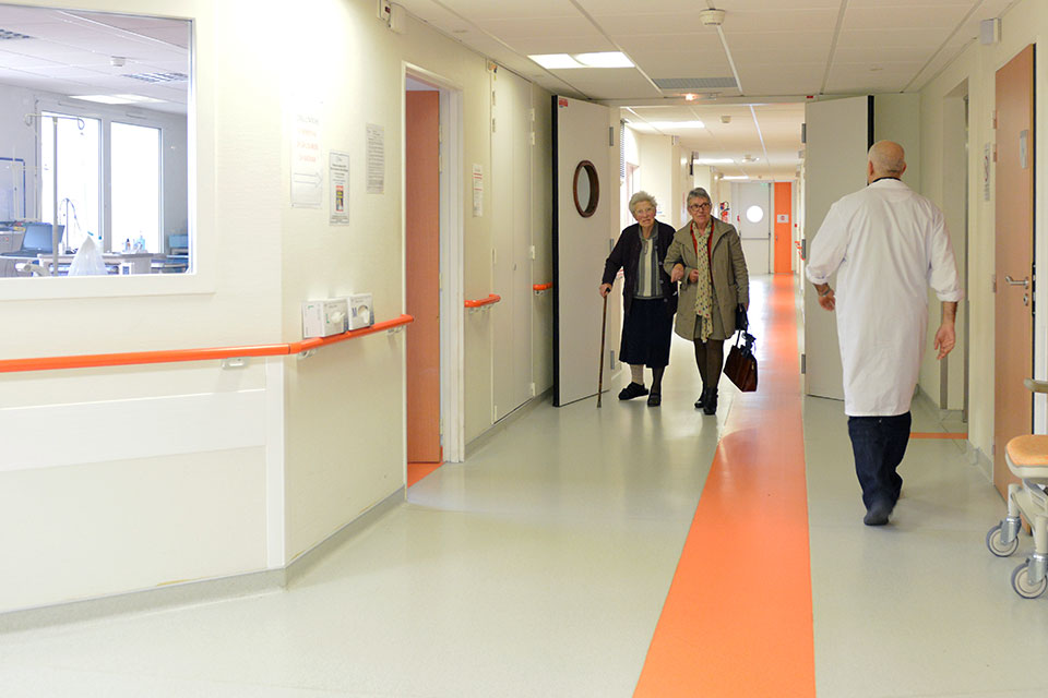 Personnes marchant dans un couloir d'hopital